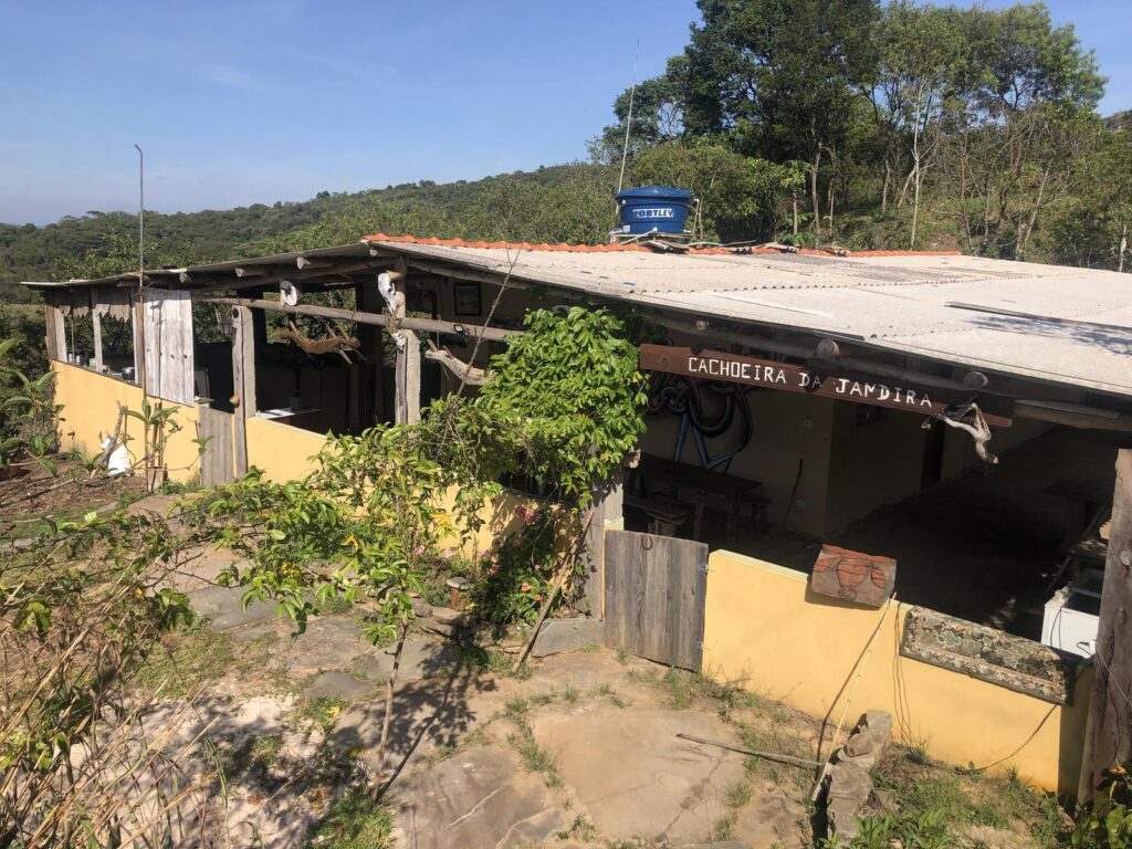 Área de camping com estrutura simples próxima à Cachoeira da Jandira, oferecendo espaço para barracas em ambiente natural.