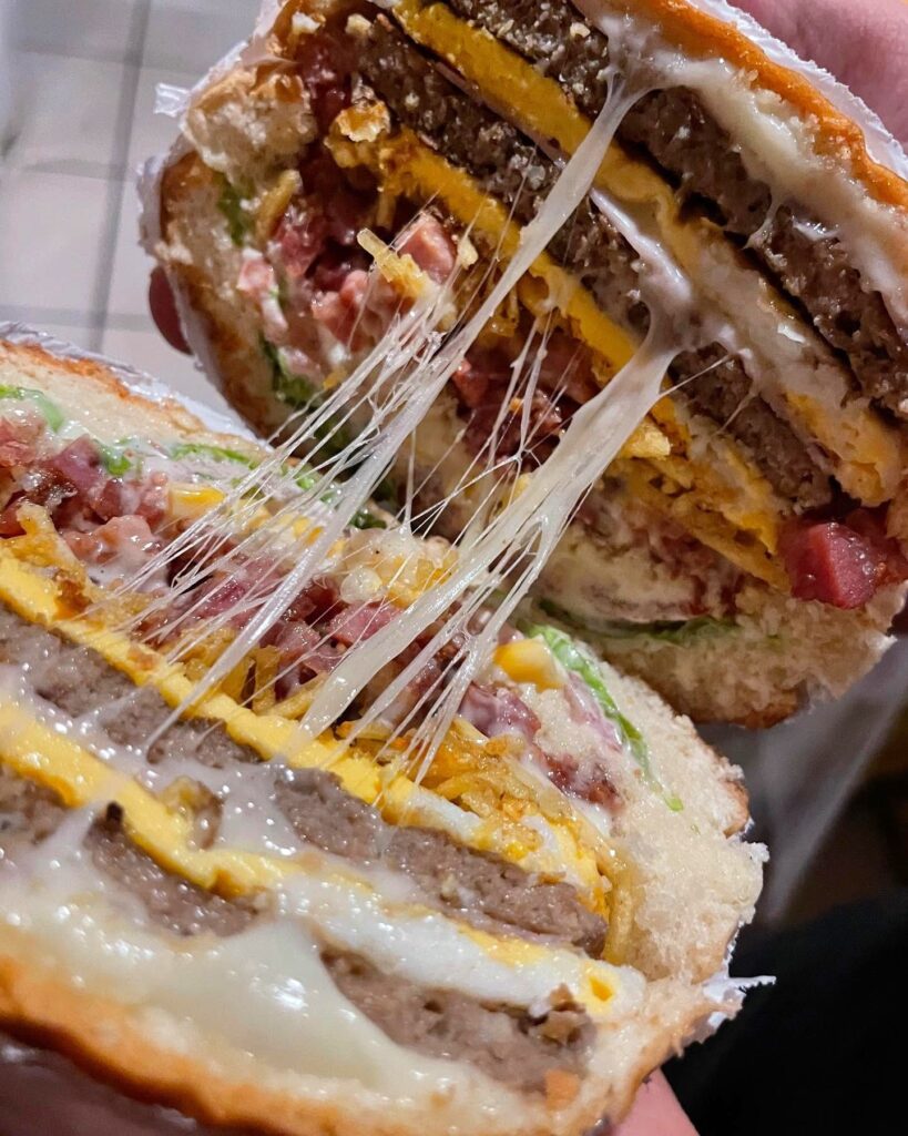 Hambúrguer artesanal do Chapa Quente Luminárias com queijo derretido, pão levemente tostado e ingredientes frescos – sabor que conquista no primeiro olhar.