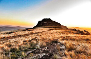 Vista panorâmica do Pico do Cruzeiro ao amanhecer, destacando as formações rochosas e a vegetação típica da Serra Grande.
