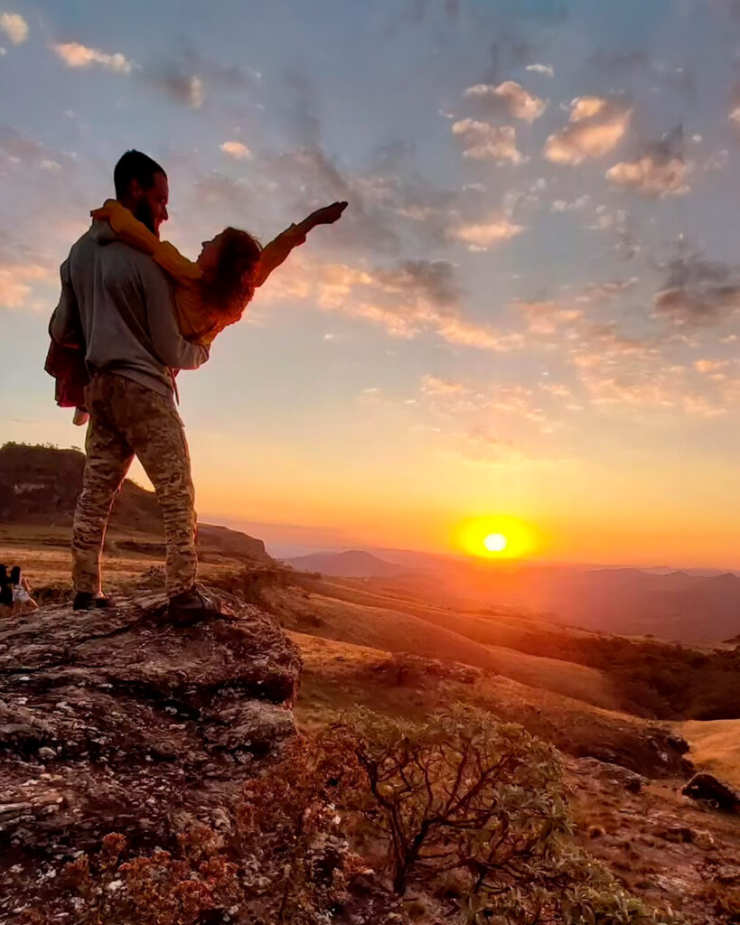 Pôr do sol no Pico do Cruzeiro, iluminando o céu com tons alaranjados e realçando a silhueta