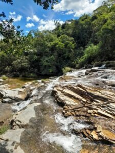 Detalhe da queda d’água escorrendo suavemente sobre as pedras, característica da formação em cascata.