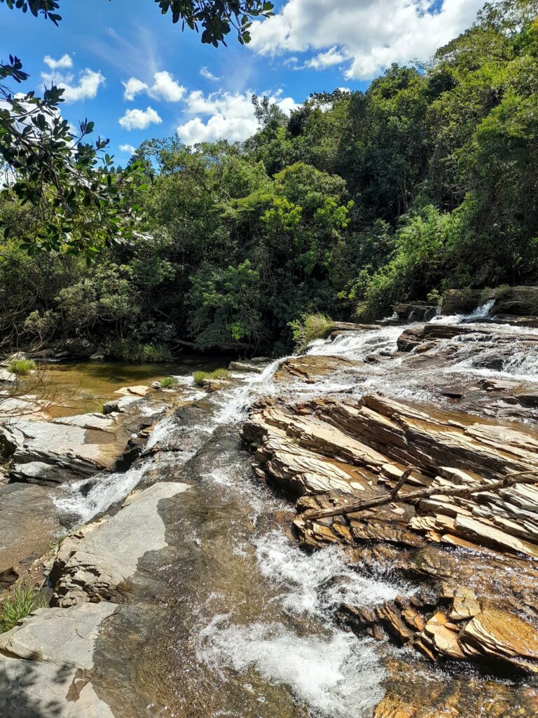 Detalhe da queda d’água escorrendo suavemente sobre as pedras, característica da formação em cascata.