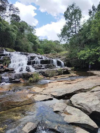 Vista ampla da Cachoeira da Libélula, com sua formação em degraus de pedra e vegetação nativa ao redor