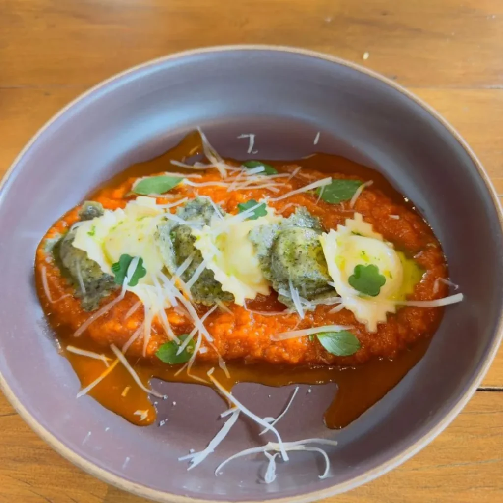 Luminárias recebe estudantes do UniBH em parceria com Le Cordon Bleu em projeto gastronômico e cultural 3 O Ravioli de frango e ora-pro-nóbis, servido com molho pomodoro e azeite de manjericão. Um exemplo da fusão entre a culinária mineira e as técnicas da alta gastronomia.